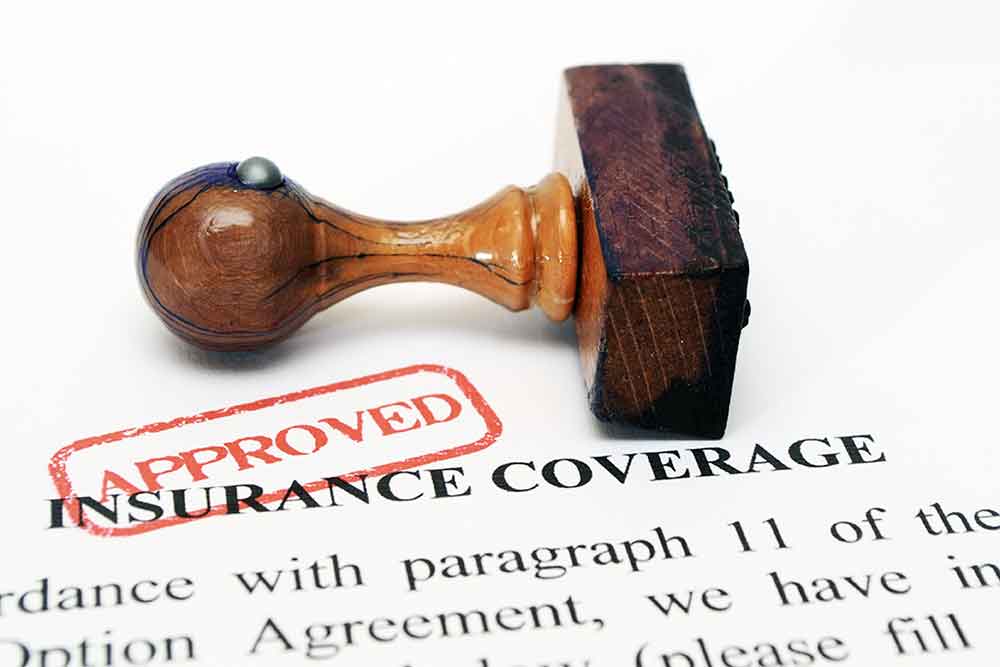 a rubber stamp on an insurance document. The doc is stamped Approved